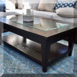 F65. Glass top coffee table. 18”h x 47”w x 28”d 
